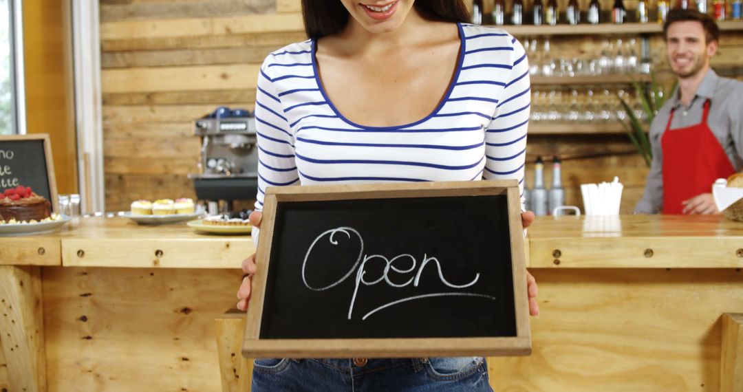 Smiling Cafe Staff Holding Open Sign in Rustic Coffee Shop - Free Images, Stock Photos and Pictures on Pikwizard.com