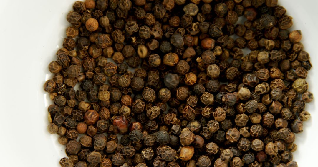 Close-Up of Dried Black Peppercorns in Dish on White Background - Free Images, Stock Photos and Pictures on Pikwizard.com