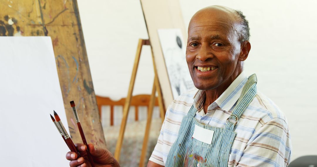 Senior African American Man Smiling While Painting in Art Studio - Free Images, Stock Photos and Pictures on Pikwizard.com