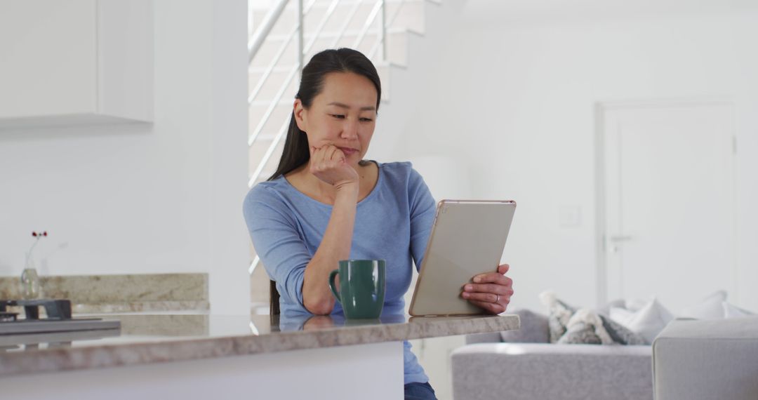 Woman Reading Tablet at Kitchen Counter - Free Images, Stock Photos and Pictures on Pikwizard.com