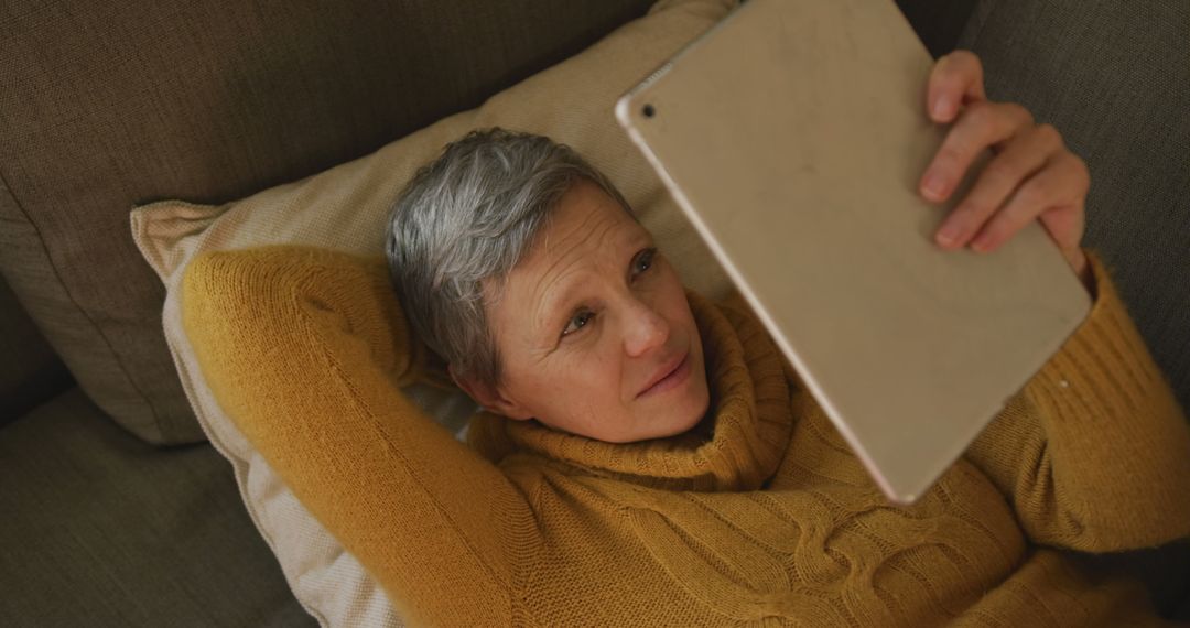 Senior Woman Relaxing on Couch Using Tablet - Free Images, Stock Photos and Pictures on Pikwizard.com