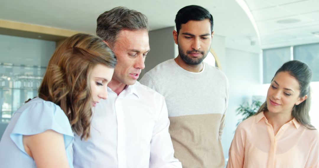 Business Team Collaborating in Modern Office Using Digital Tablet