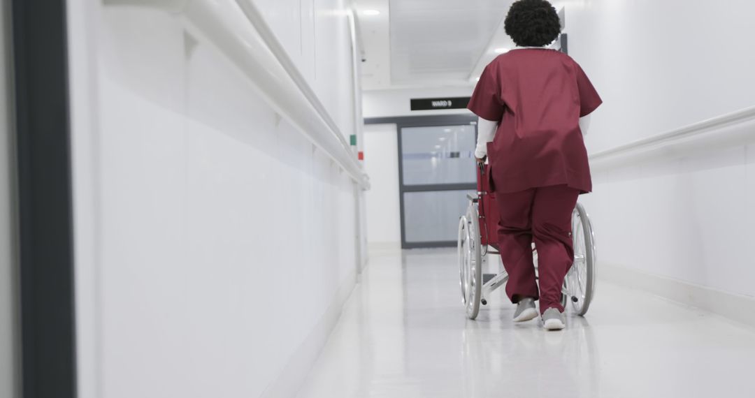 Nurse Assisting Hospital Patient in Wheelchair Down Hallway - Free Images, Stock Photos and Pictures on Pikwizard.com