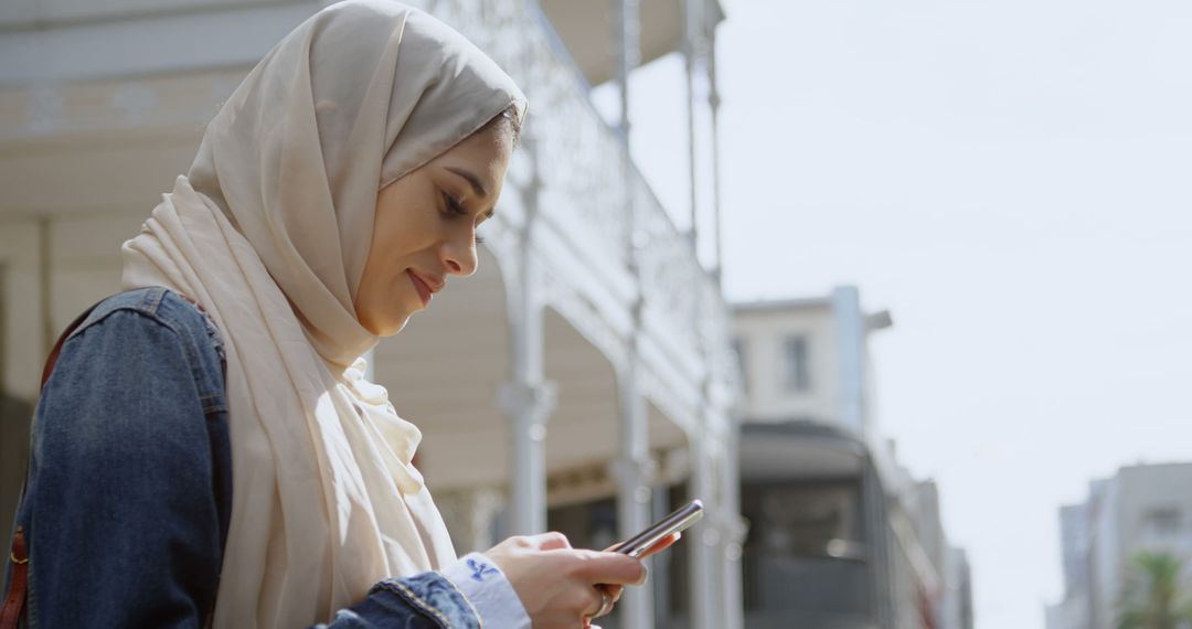 Young Muslim Woman Using Smartphone in Urban Area - Free Images, Stock Photos and Pictures on Pikwizard.com