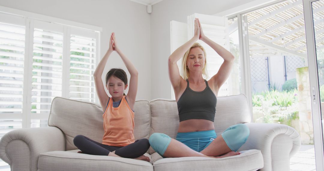 Mother and Daughter Meditating Together on Couch in Living Room - Free Images, Stock Photos and Pictures on Pikwizard.com