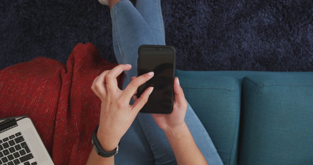 Biracial Woman Relaxing on Couch Using Smartphone and Laptop - Free Images, Stock Photos and Pictures on Pikwizard.com