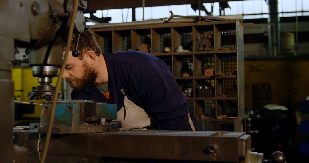 Focused Machinist Operating Industrial Equipment in Workshop