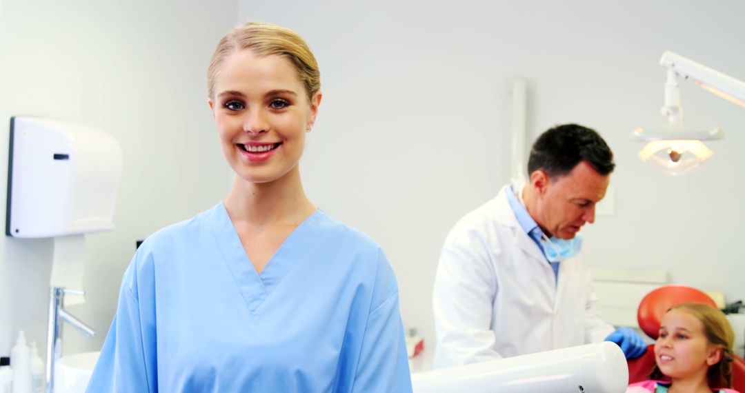 Smiling Dental Assistant in Clinic with Dentist Treating Young Patient - Free Images, Stock Photos and Pictures on Pikwizard.com