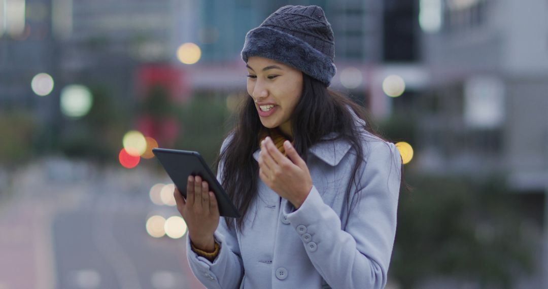 Young Woman Outdoors Using Tablet Surrounded by City Lights - Free Images, Stock Photos and Pictures on Pikwizard.com