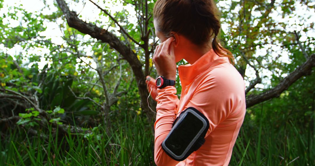 Woman Preparing for Jog in Forested Area with Fitness Tracker - Free Images, Stock Photos and Pictures on Pikwizard.com