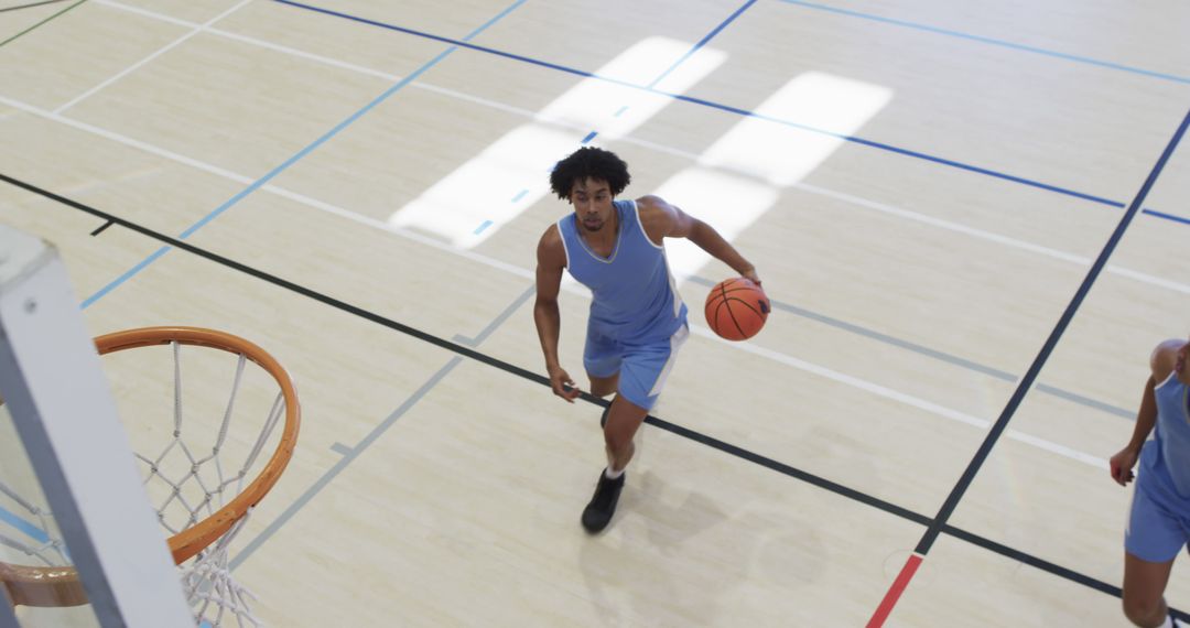 Basketball Player Dribbling Ball on Court Aiming for Hoop - Free Images, Stock Photos and Pictures on Pikwizard.com