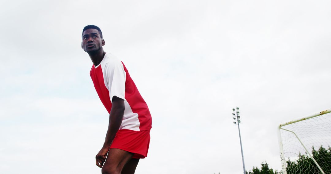 Focused Soccer Player in Red Uniform on Sunny Day