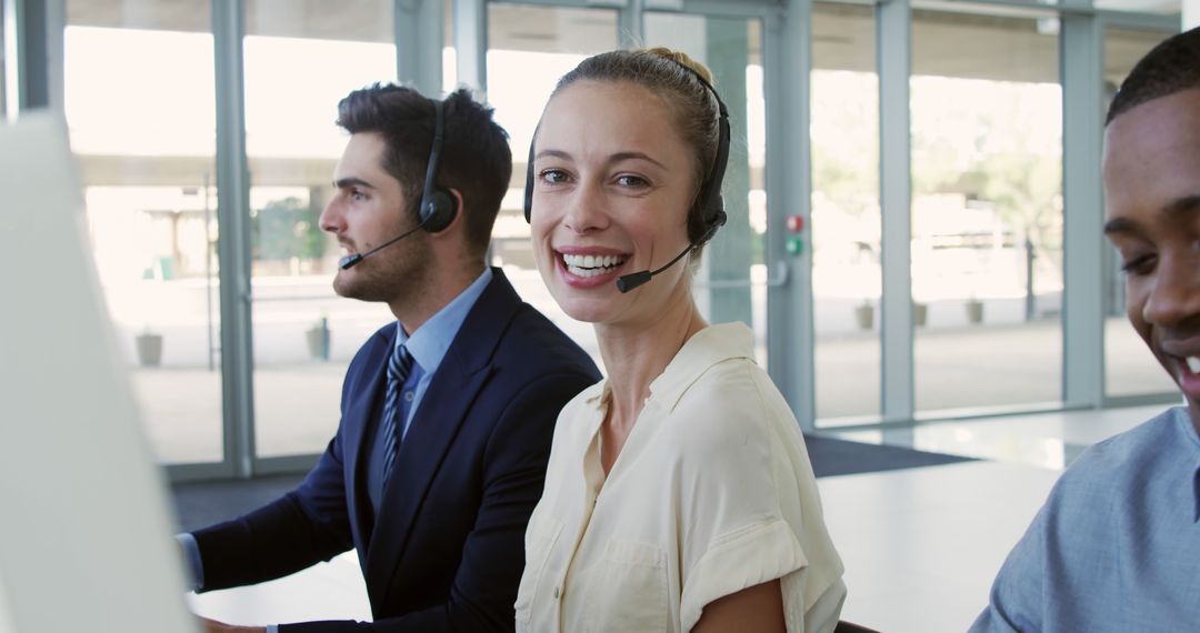 Smiling Customer Service Team Working with Headsets in Modern Office - Free Images, Stock Photos and Pictures on Pikwizard.com