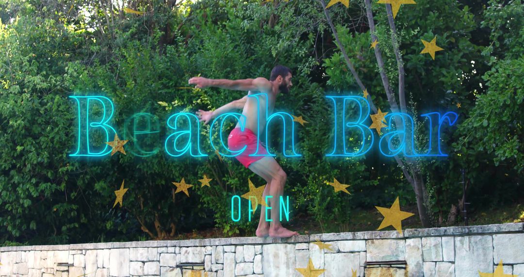 Crouching Man Balancing on Stone Wall with Neon Beach Bar OPEN Sign in Sunlit Backyard