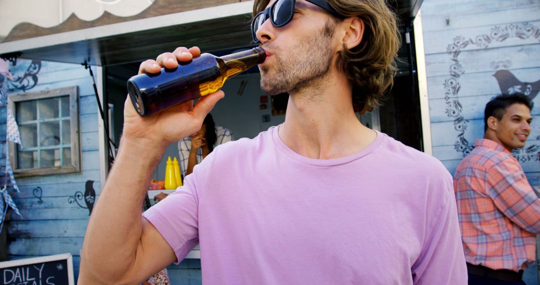 Man Enjoying Refreshing Beverage at Outdoor Market - Free Images, Stock Photos and Pictures on Pikwizard.com