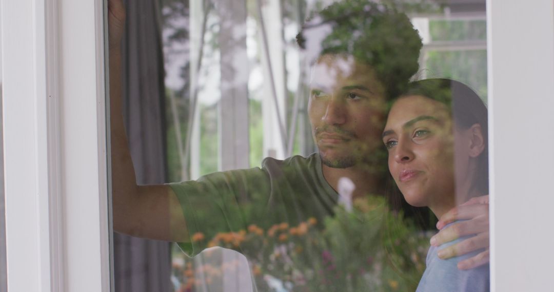 Thoughtful Multiracial Couple Gazing through Window Together