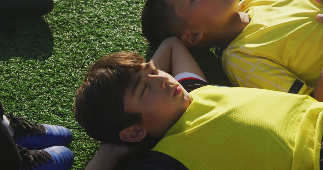 Children Resting on Grass After Sports Activity - Free Images, Stock Photos and Pictures on Pikwizard.com