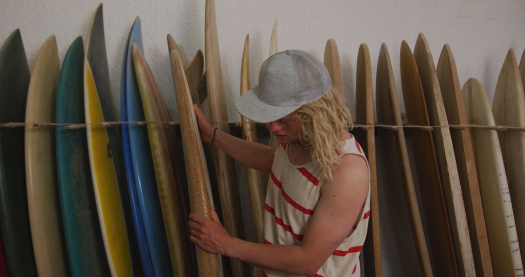 Male Surfer Choosing Surfboard in Surf Shop - Free Images, Stock Photos and Pictures on Pikwizard.com