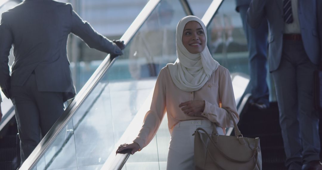 Confident Muslim Businesswoman on Escalator - Free Images, Stock Photos and Pictures on Pikwizard.com