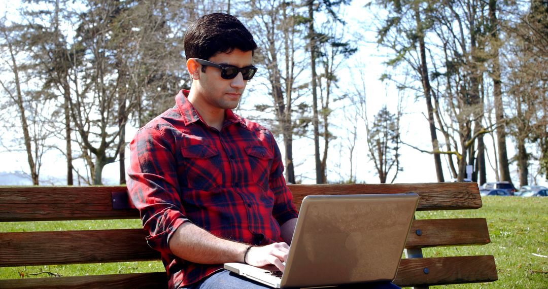 Young Man Working Outdoors on Laptop in Park - Free Images, Stock Photos and Pictures on Pikwizard.com