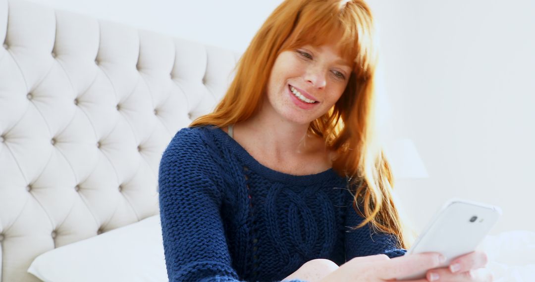 Smiling Red-haired Woman Using Smartphone in Bed - Free Images, Stock Photos and Pictures on Pikwizard.com