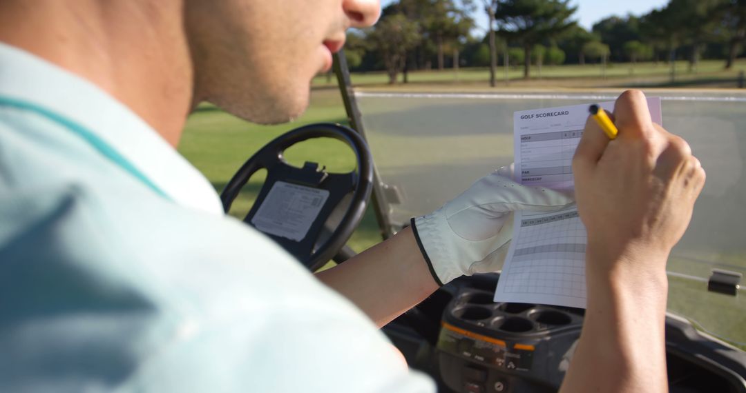 Golfer Writing on Scorecard in Golf Cart on Sunny Day - Free Images, Stock Photos and Pictures on Pikwizard.com