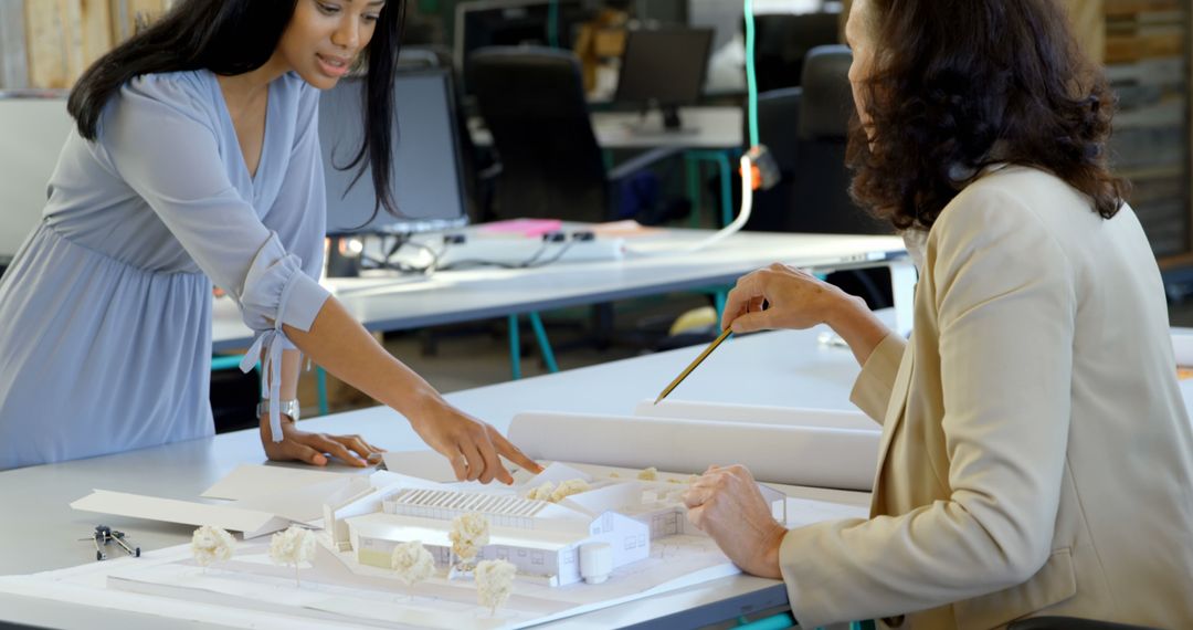 Two Female Architects Discussing Architectural Model in Office - Free Images, Stock Photos and Pictures on Pikwizard.com