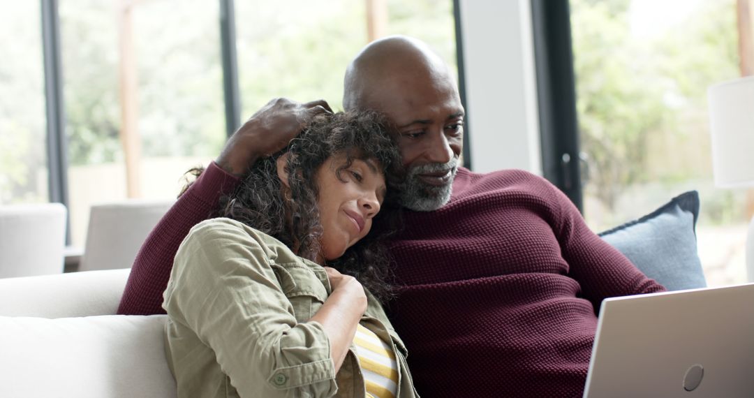 Happy Couple Relaxing Together and Using Laptop at Home