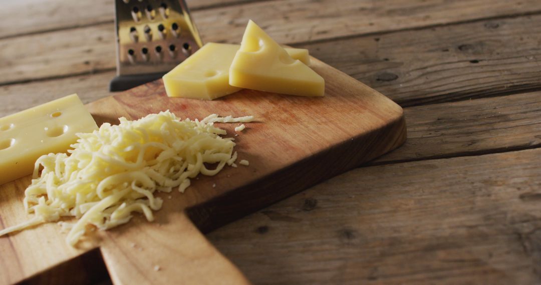 Grated Cheese and Cheese Slices on Wooden Cutting Board with Grater - Free Images, Stock Photos and Pictures on Pikwizard.com