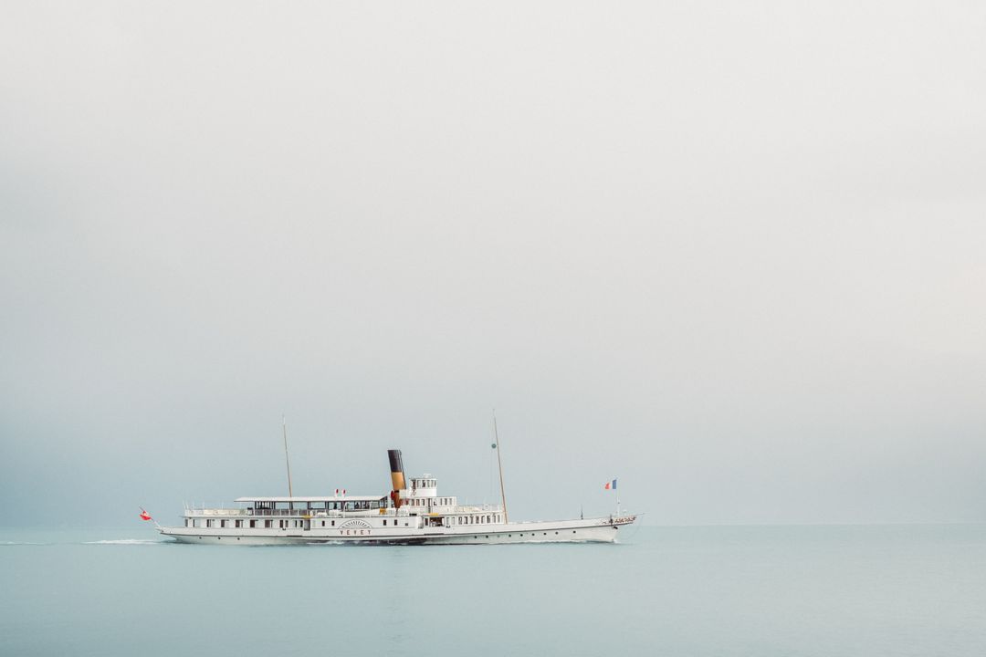 Vintage Passenger Steamboat Sailing on Calm Sea Against Minimalist Sky - Free Images, Stock Photos and Pictures on Pikwizard.com