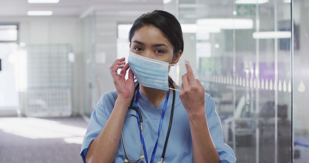 Healthcare Worker Adjusting Facemask in Hospital Ward - Free Images, Stock Photos and Pictures on Pikwizard.com