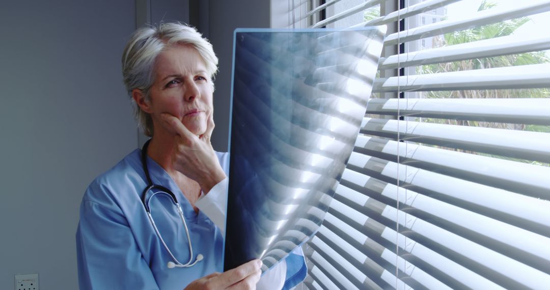 Senior Doctor Analyzing X-ray in Office - Free Images, Stock Photos and Pictures on Pikwizard.com