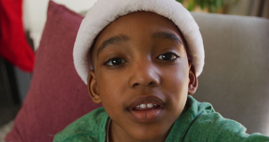 Child Wearing Santa Hat Smiling Indoors - Free Images, Stock Photos and Pictures on Pikwizard.com