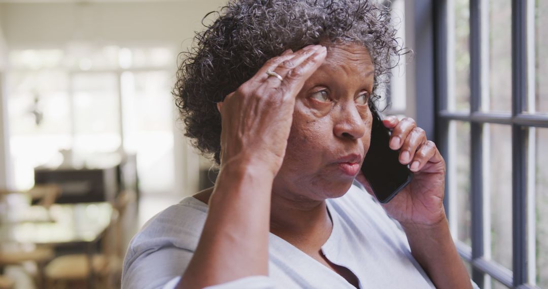 Senior Woman Looking Concerned While Talking on Phone at Home - Free Images, Stock Photos and Pictures on Pikwizard.com