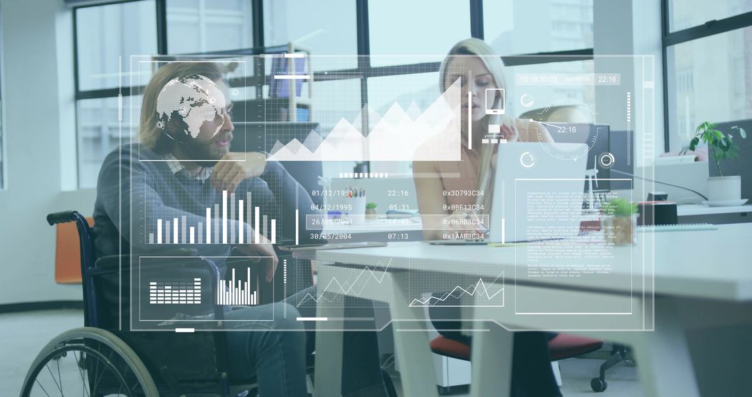Collaborating wheelchair user and coworker analyzing digital dashboards in modern office