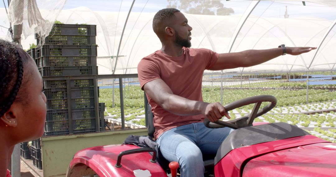 Man Discussing Hydroponic Farm Operations while Driving Tractor