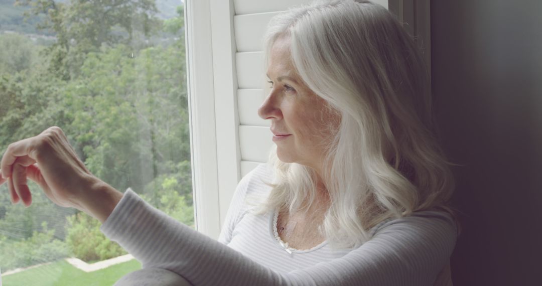 Senior Woman Relaxing by Window, Enjoying Scenic View - Free Images, Stock Photos and Pictures on Pikwizard.com