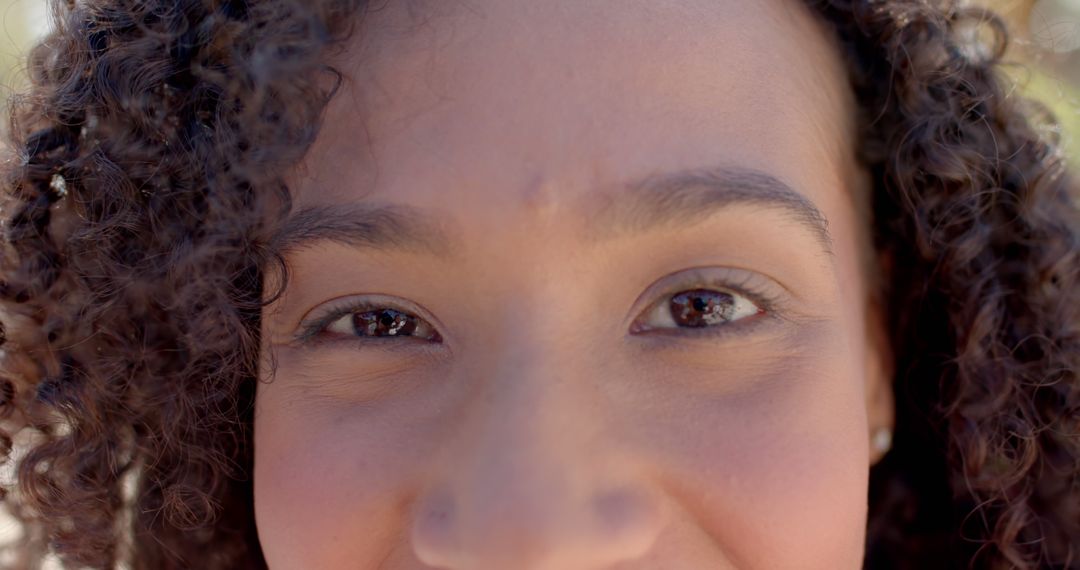 Close-up of Woman with Curly Hair Showing Bright Eyes - Free Images, Stock Photos and Pictures on Pikwizard.com