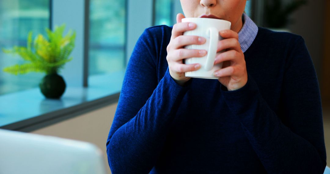 Person Enjoying Coffee Break by Window in Modern Office - Free Images, Stock Photos and Pictures on Pikwizard.com