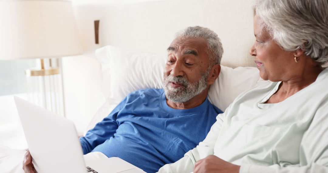 Senior Couple Engaging with Technology in Cozy Bedroom