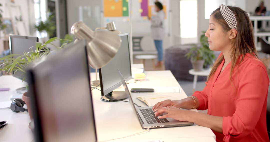 Woman Typing on Laptop in Modern Office