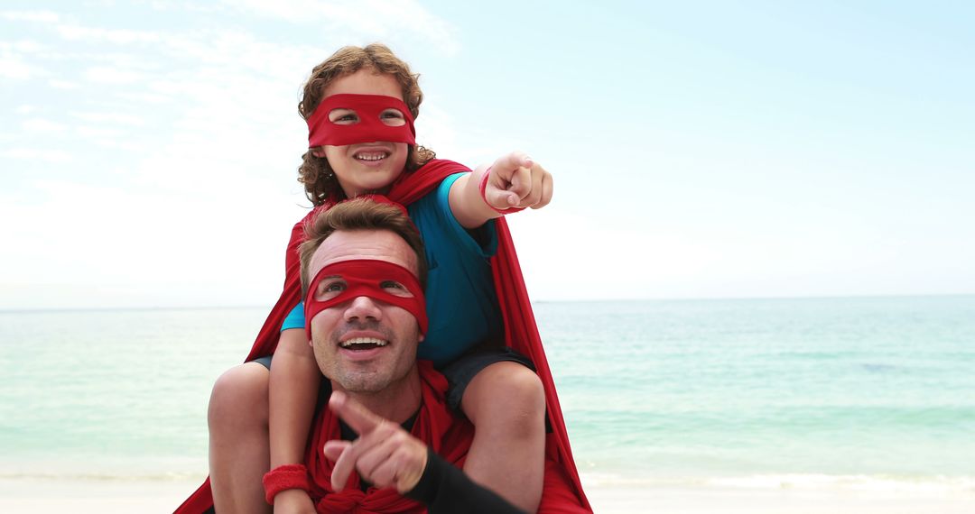 Father and Daughter in Superhero Costumes at Beach Pointing - Free Images, Stock Photos and Pictures on Pikwizard.com