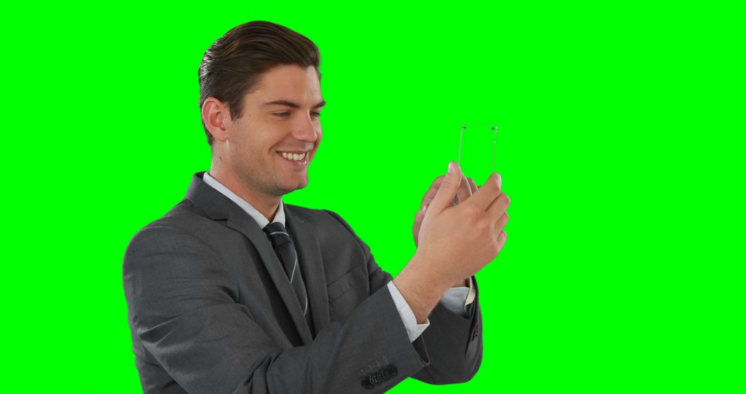 Smiling Businessman Using Transparent Digital Tablet on Green Screen Background - Free Images, Stock Photos and Pictures on Pikwizard.com