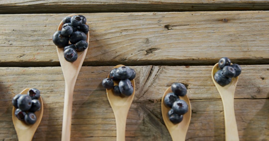 Fresh Blueberries on Wooden Spoons Displayed on Rustic Wooden Surface - Free Images, Stock Photos and Pictures on Pikwizard.com