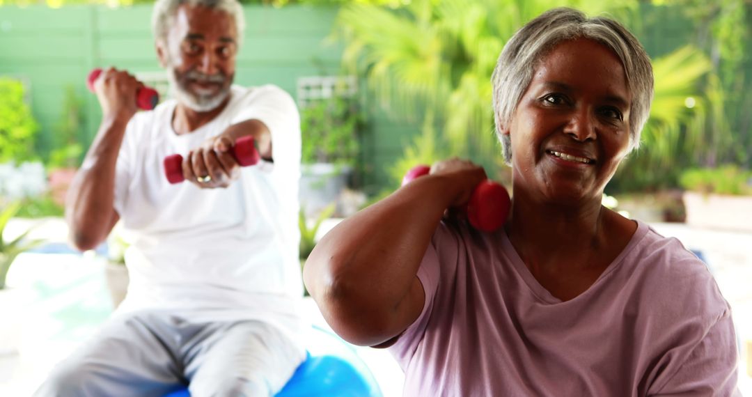 Active Senior Couple Exercising Together with Dumbbells at Home