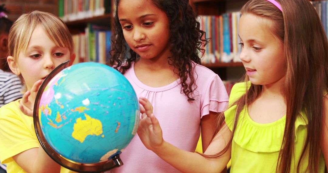 Curious Children Exploring Globe in Library - Free Images, Stock Photos and Pictures on Pikwizard.com