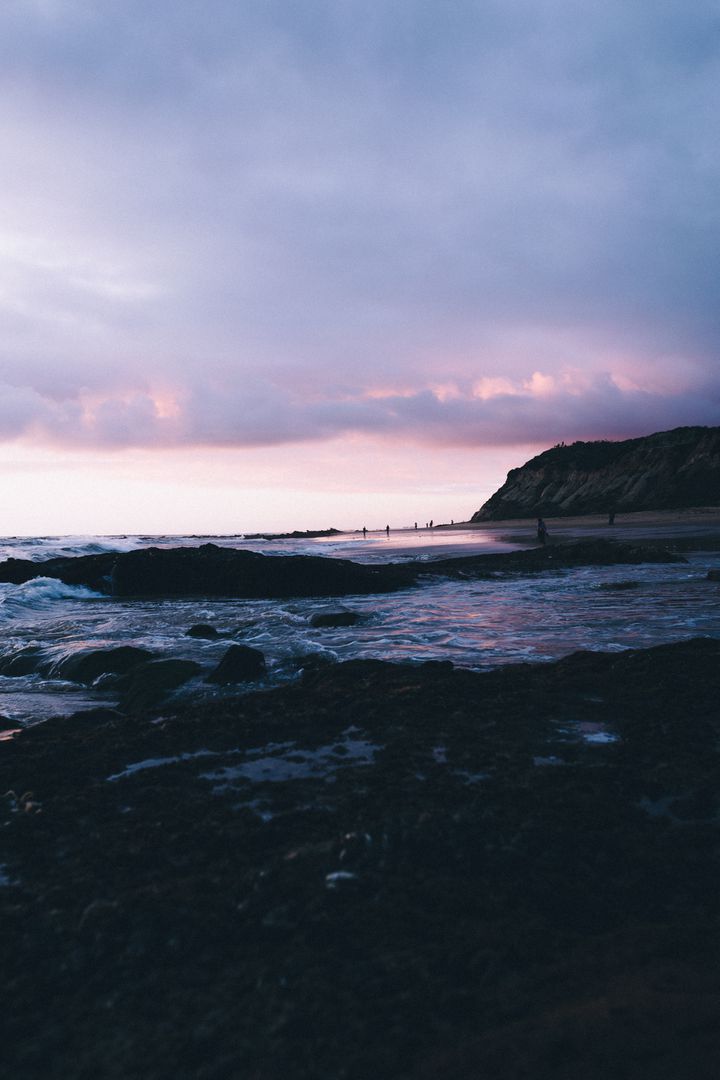 Sunset Over Rocky Shoreline With Rolling Waves and Cloudy Sky - Free Images, Stock Photos and Pictures on Pikwizard.com