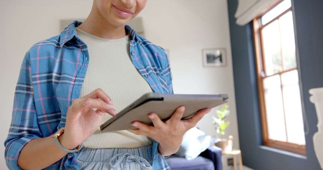 Smiling Teenage Girl Using Tablet at Home