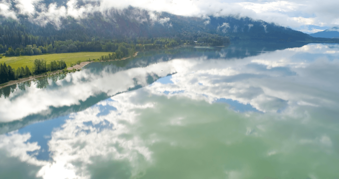 Serene Reflection of Clouded Sky on Tranquil Mountain Lake