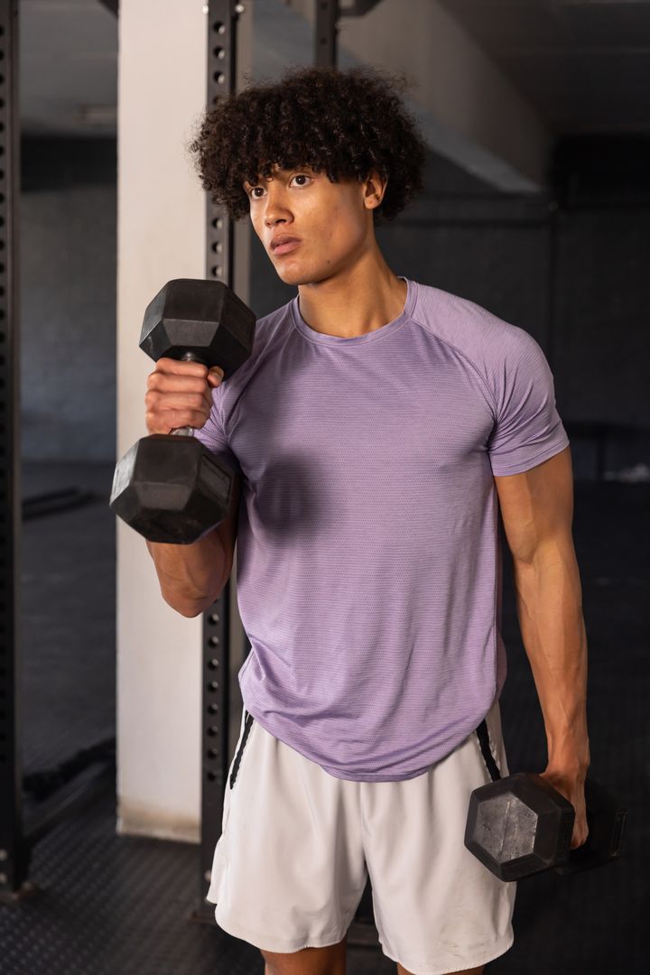 Man Lifting Dumbbells in Gym for Strength Training Workout